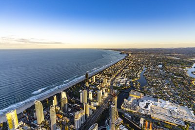 A high-altitude aerial view of Surfers Paradise and the Gold Coast coastline looking south at golden hour.