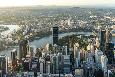 Aerial view over West End, Brisbane showing the city's skyline and river.
