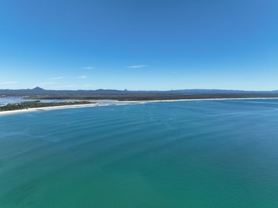 A high-altitude aerial view of Laguna Bay, showcasing the Noosa Spit sand bar and coastline.