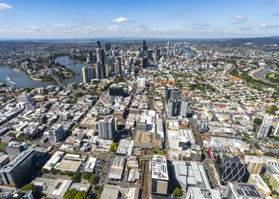 A sweeping aerial view of Brisbane CBD with the Brisbane River and inner suburbs on a clear day.
