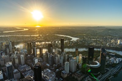 Aerial view over West End, Riverside Drive and the Brisbane skyline during sunset.