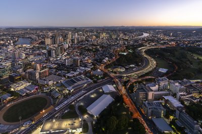 Aerial dusk view of Brisbane city with Pacific Motorway interchange and southern suburban sprawl.