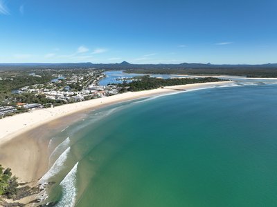 Aerial view of Noosa Heads coastline with Main Beach, river mouth and hinterland extending inland.