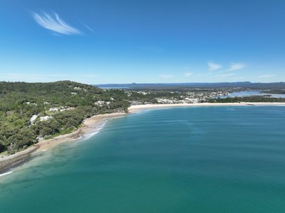 Aerial view from north of Noosa showing Little Cove, the headland, Noosa township, and Sunshine Coast hinterland.