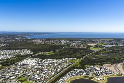 Aerial view of Mango Hill and North Lakes residential development with Moreton Bay on the horizon.