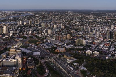 Aerial twilight view of inner south Brisbane with CBD towers visible in the distance.