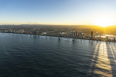 Aerial morning view of the Gold Coast coastline showing Broadbeach and Surfers Paradise, with high-rise buildings along the skyline strip.