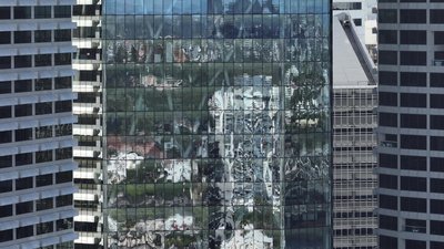 Abstract aerial view of Brisbane CBD glass tower facade reflecting surrounding city buildings.