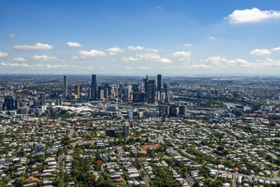 Aerial view of Brisbane CBD skyline with residential suburbs in the foreground.