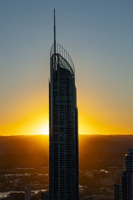 Aerial silhouette of the Q1 tower against a deep orange sunset over Surfers Paradise, Gold Coast.
