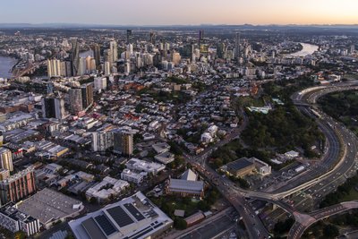 Aerial dusk view of South Brisbane with the Ipswich Motorway interchange and CBD in distance.