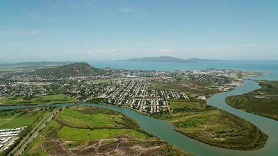 Aerial view of Townsville with Ross River meanders, port facilities and Magnetic Island beyond.