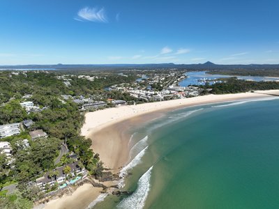 Aerial view of Noosa Main Beach from the headland looking south showing the full sweep of the beach, Noosa township and Noosa Sound.