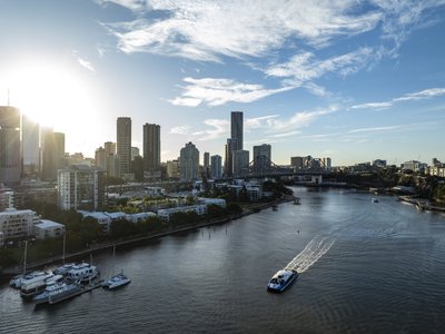 Aerial view of New Farm Riverwalk, with Story Bridge and CBD towers in the background.