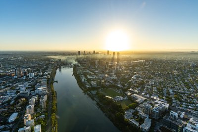 Aerial view over West End, Brisbane showing the river and city skyline.