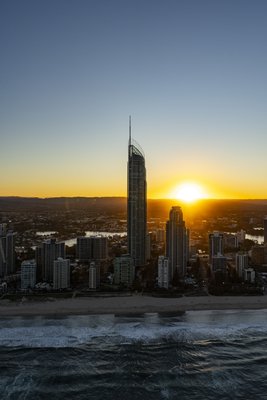 Aerial view of Surfers Paradise beach and Q1 tower at sunset with the Pacific Ocean.