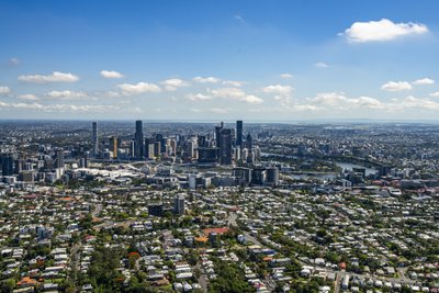 A clear day aerial panorama of Brisbane CBD with the river and inner suburbs visible.