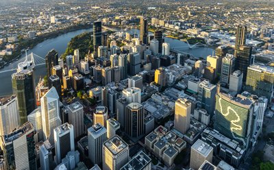 Aerial view over West End, Brisbane showing the city's skyline and river.