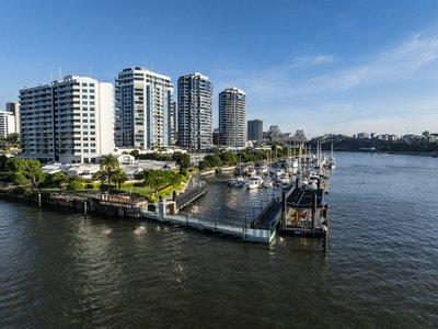 Aerial view of Brisbane's New Farm riverside apartments, marina and Story Bridge in the background.