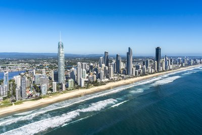 Aerial view of the Gold Coast's Surfers Paradise beach strip, showcasing the Q1 tower and coastal skyline.