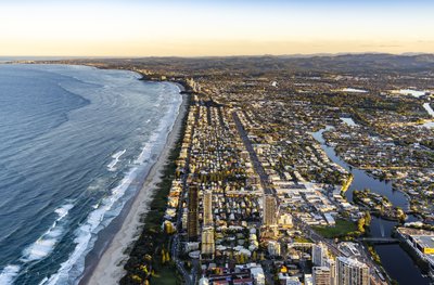 A low aerial view of the Gold Coast coastline looking north toward Surfers Paradise at golden hour.