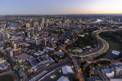 Aerial twilight view of illuminated Pacific Motorway and CBD skyline from south in Brisbane, Queensland.