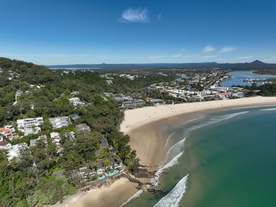 Aerial view of Noosa Heads with Main Beach, town and river mouth visible.