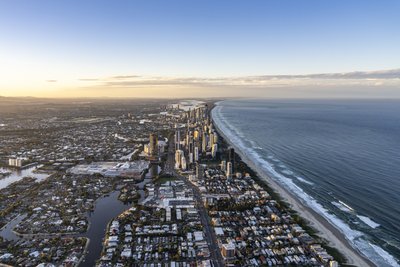 Aerial sunrise view of the Gold Coast strip, showcasing Surfers Paradise skyline and beach.