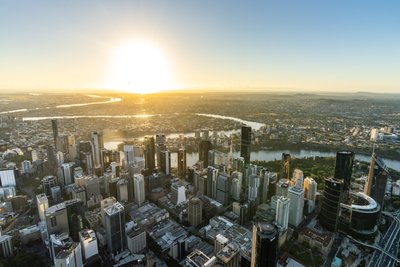 Aerial view of Brisbane's West End suburb, showcasing high-rise buildings along Riverside Drive with the Brisbane River in the background.