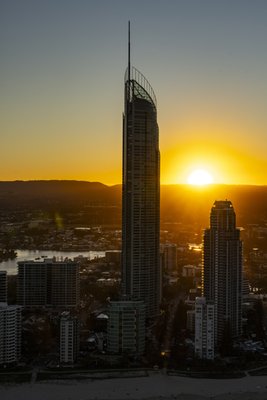 Aerial view of the Q1 tower and Surfers Paradise beach precinct during a golden sunset.