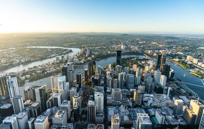 Aerial view of Brisbane City's West End suburb, showcasing the city centre skyline and surrounding river.