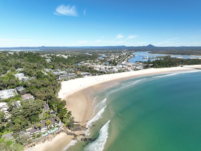 Aerial view of Noosa Main Beach and Noosa Heads with the national park on the left and the full town visible to the south.