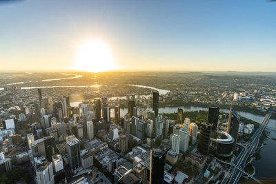 Aerial view over West End, Riverside Drive and the Brisbane skyline at sunset.